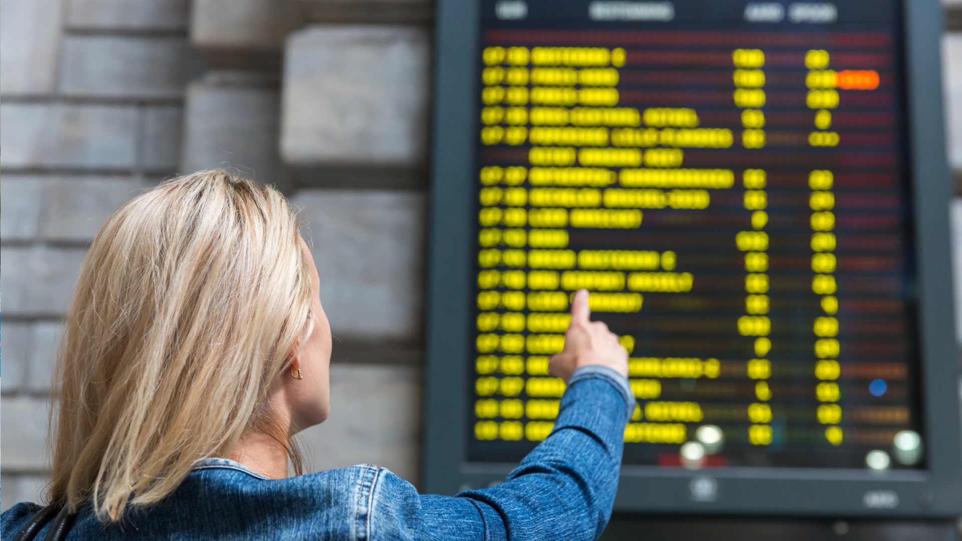 A woman looks at the bus schedule