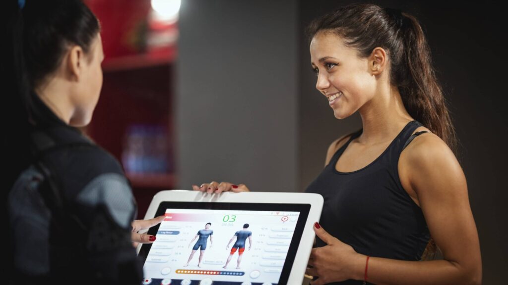 A personal trainer or manager discussing fitness goals with a client