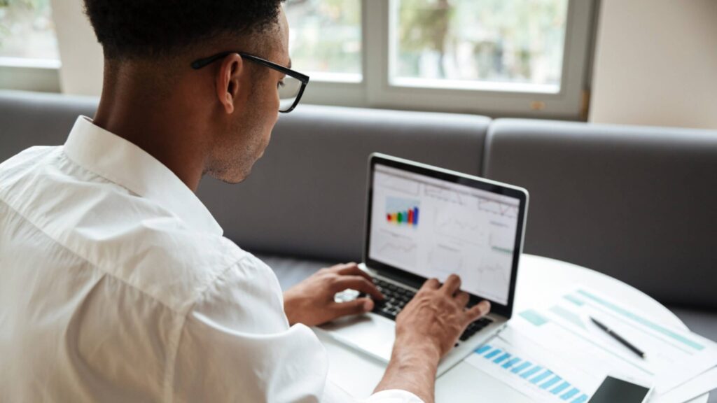 Person using a laptop with CRM-style dashboards and list views